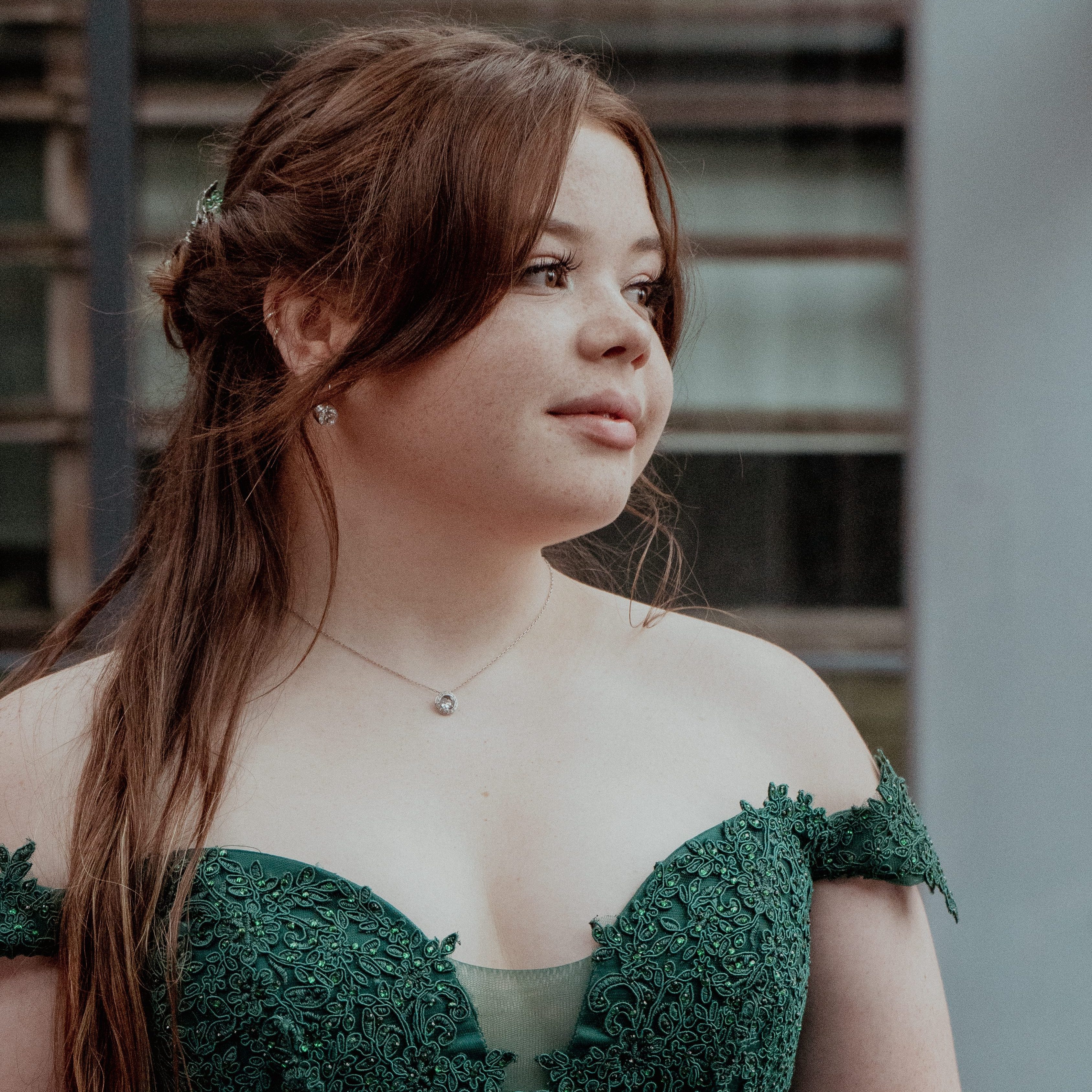 Teenage girl wearing an emerald green prom dress.